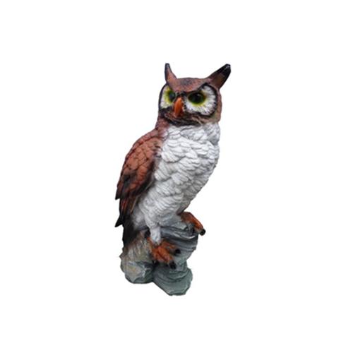 Decorative sculpture designed as a original colored owl with green eyes standing on a stone 38cm