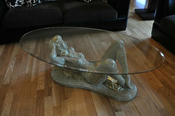 Living room glass oval coffee table with semi-naked acrylic woman sculpture