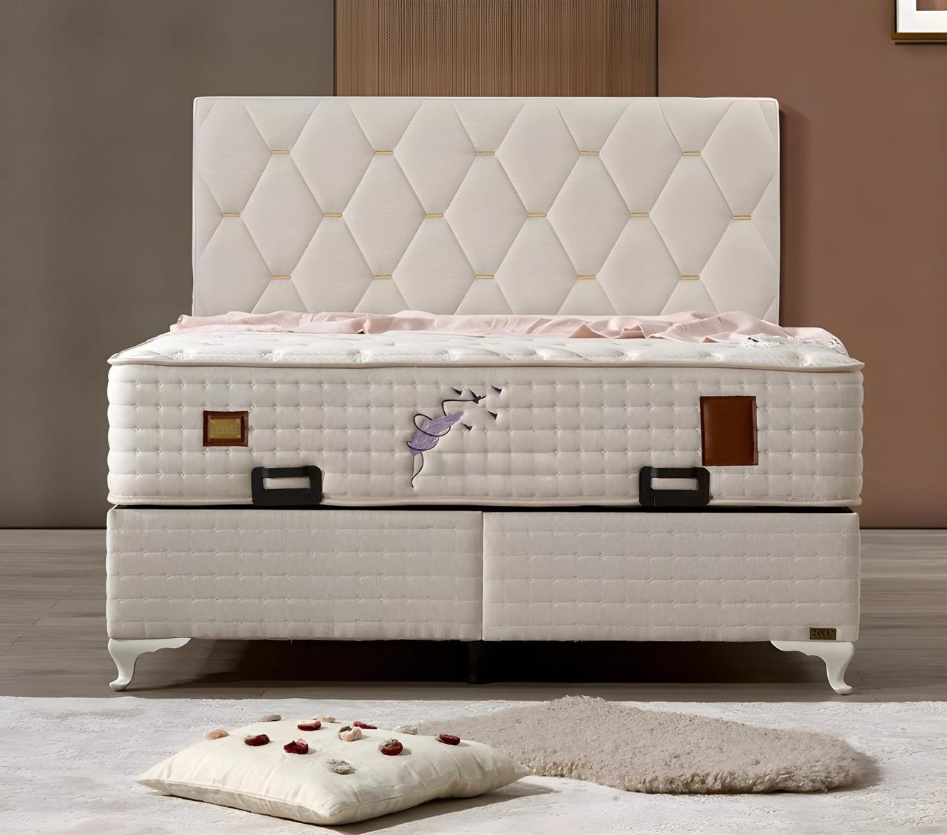 Elegant white bed with textile and wooden mattress.