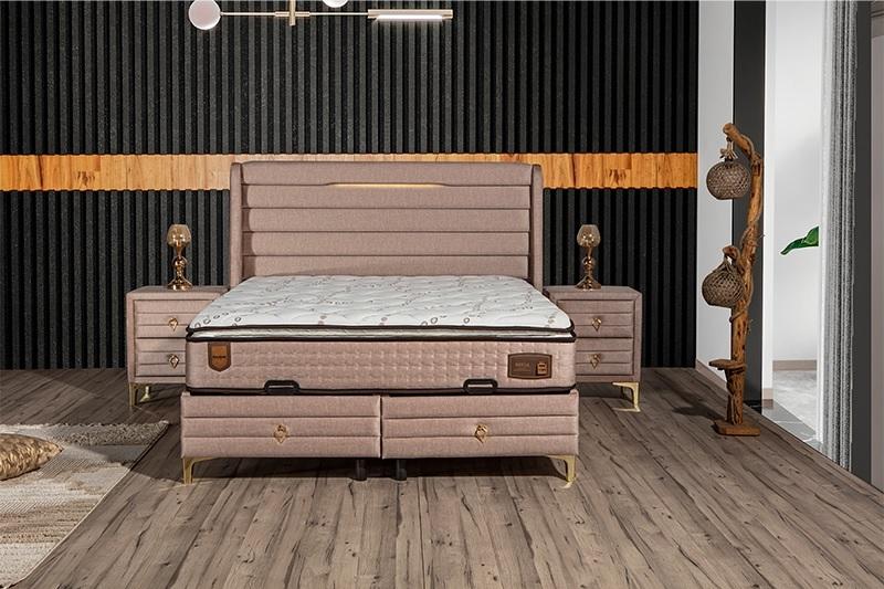 Elegant bed with mattress in beige textile and stainless steel.