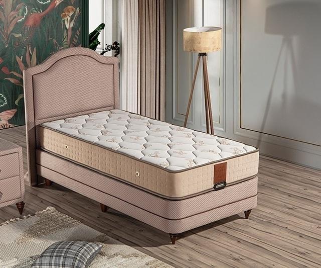 Elegant bed with mattress made of wood and textile in beige tones.