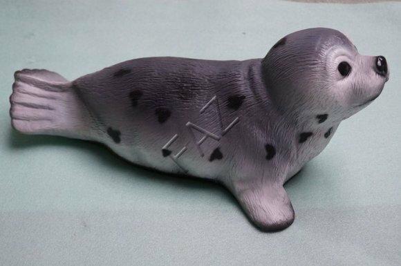 Decorative sculpture designed as grey colored motley seal in grey black colored