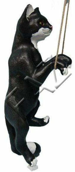 Decorative sculpture designed as motley black white colored climbing on a rope cat with green eyes 65cm height