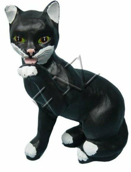 Licking a paw sitting cat figure in motley black white colored with green eyes 48x40cm