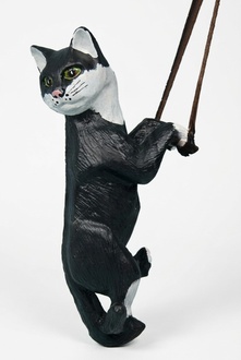 Decorative sculpture designed as a mobley white black colored cat on a rope 50cm height