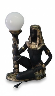 Black gold colored decor light designed as a sitting ancient egyptian servant with a lamp