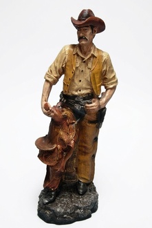 Decor figure of an original orange colored wild western cowboy on a stone 87cm