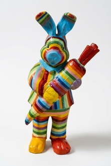 Rabbit with a carrot figure in colorful stripes decorative garden sculpture