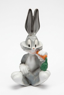 Decorative sculpture designed as gloss grey colored cartoon rabbit eating carrot