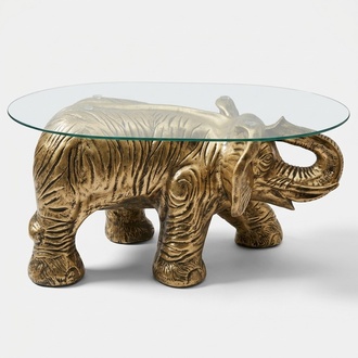 Oval glass coffee table with decorative golden elephant sculpture 40cm