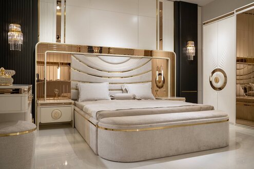 Modern white bedroom set with bed, nightstands, and bench.