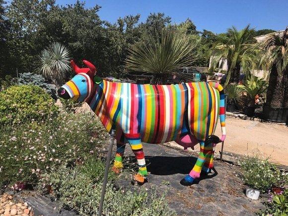 Garden abstract decorative sculpture designed as standing cow in colorful stripes 147x220cm