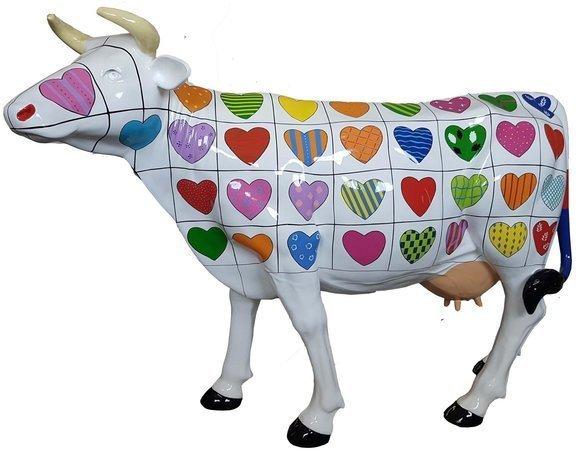 Abstract sculpture designed as white lying cow with hearts patterns 147 cm height